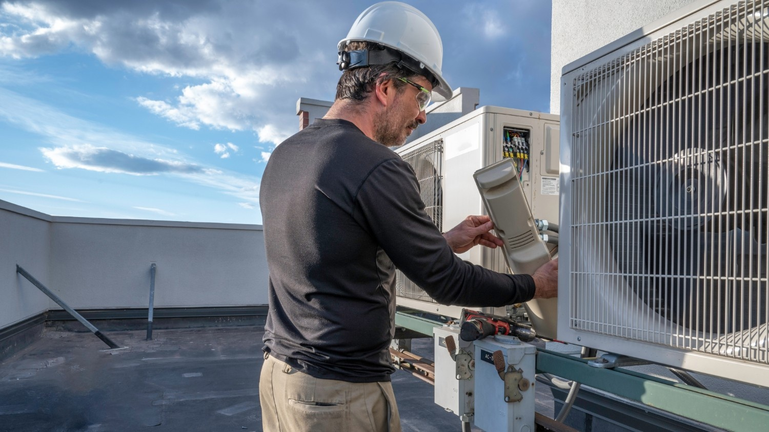 Illustrative photo of a technician servicing a commercial air conditioning unit