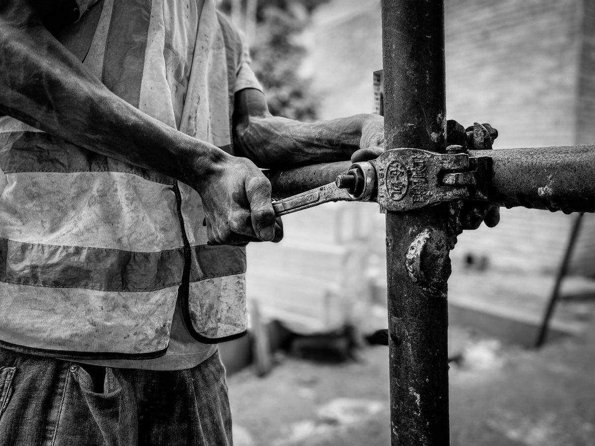 Hands tightening a pipe fitting
