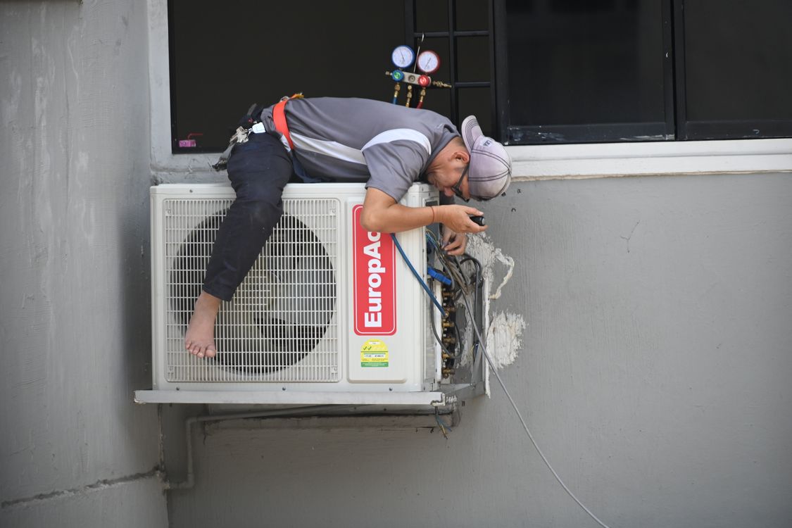 Technician servicing an outdoor air-conditioning unit