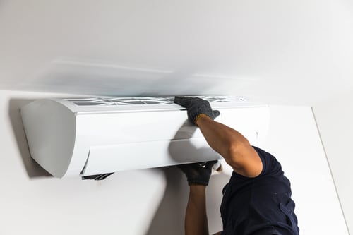 Engineer fitting an air conditioning unit