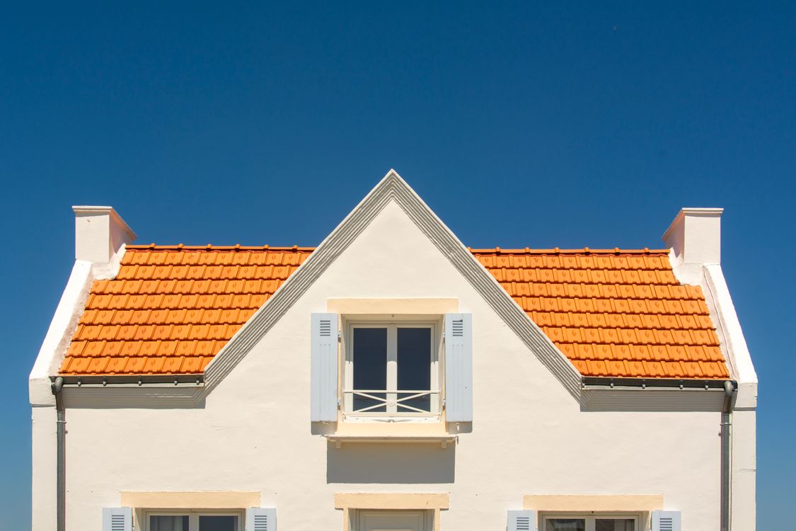 Newly tiled pitched roof on a house against a clear sky