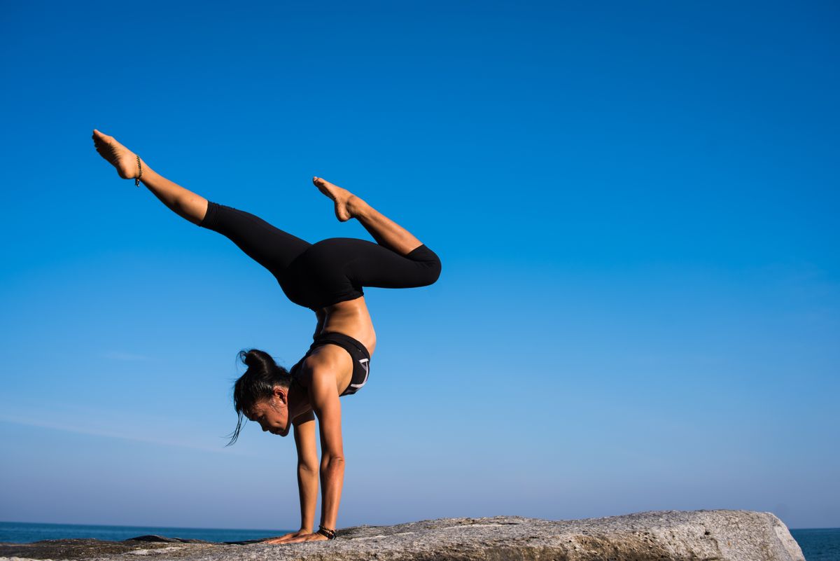 Yoga practitioner holding a pose on the beach at golden light
