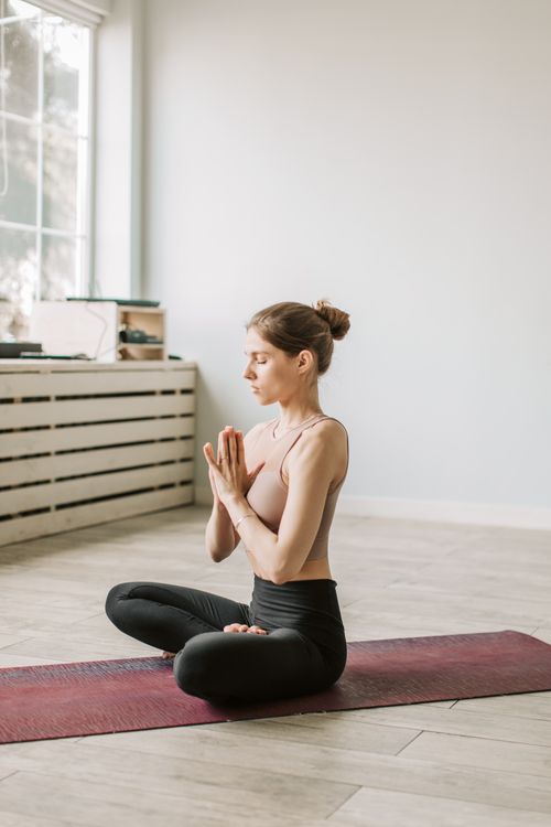 Student in seated meditation on a yoga mat